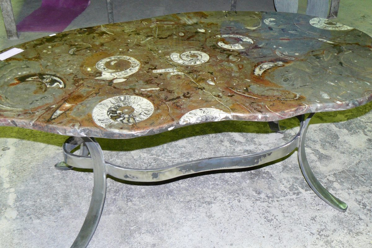 Table irrégulière en pierre d'Erfoud macrofossiles et son socle en fer de forme irrégulière. Pendant la fabrication