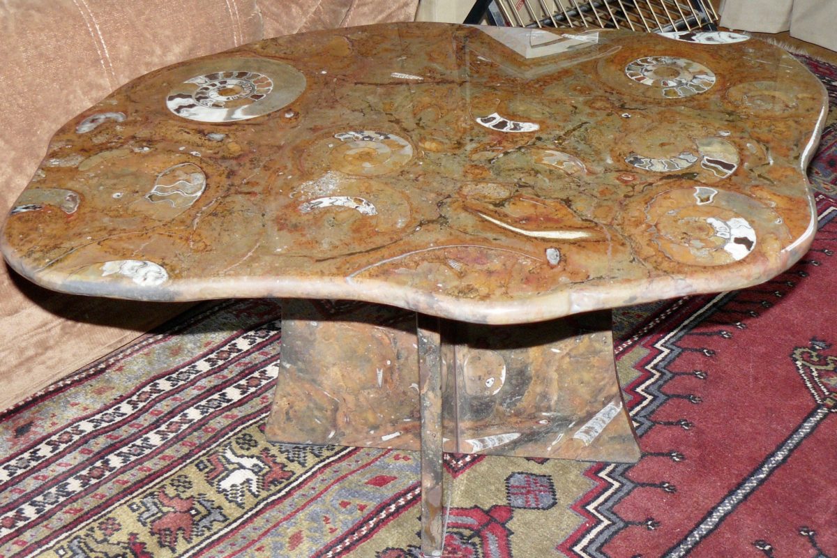 Table irrégulière en pierre d'Erfoud macrofossiles et son socle en croix