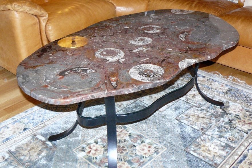 Table irrégulière en pierre d'Erfoud macrofossiles et son socle en fer de forme irrégulière